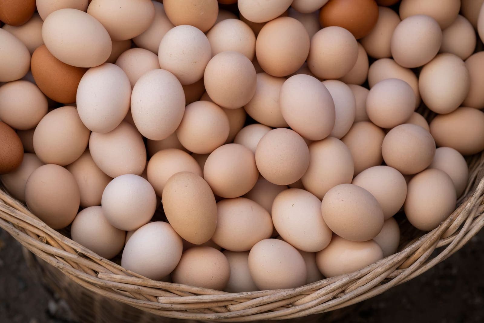 Brown and white eggs heaped in a wicker basket